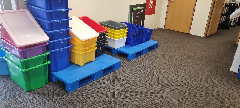 Blue plastic pallets used for workplace storage